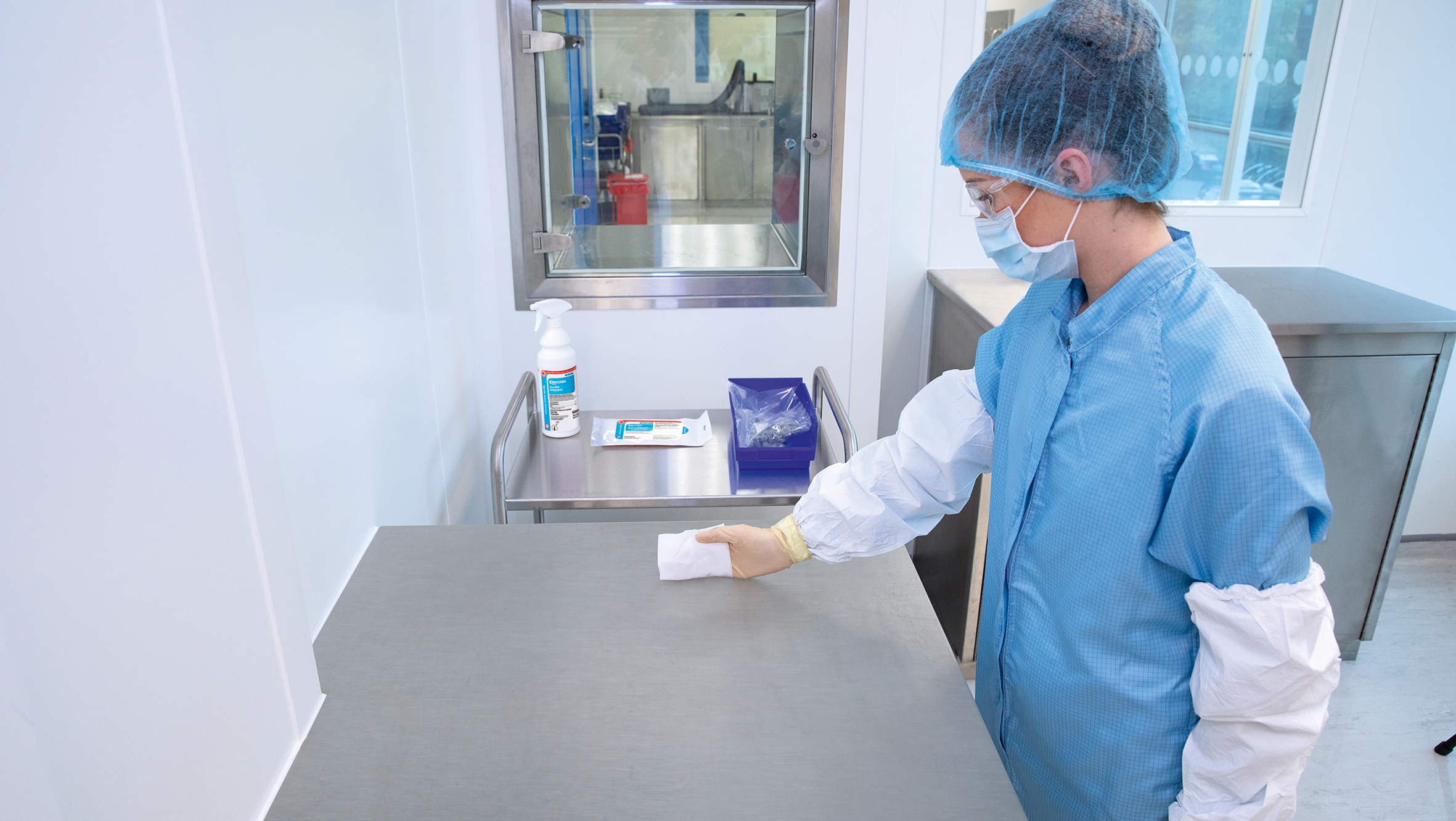 Technician using an Ecolab disinfectant in a cleanroom