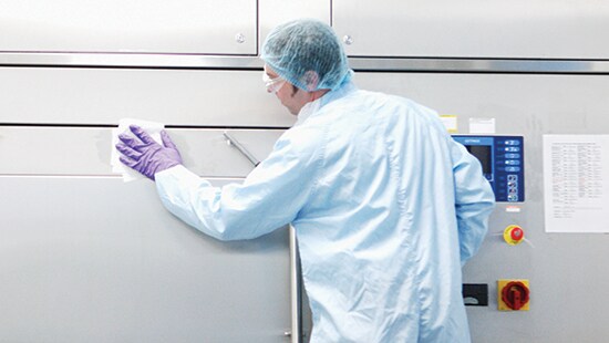 Technician using Ecolab Klercide™ wipes in a pharmaceutical plant cleanroom
