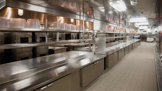 Restaurant kitchen with clean floors and shining silverware equipment after receiving floor and commercial drain cleaning treatment.