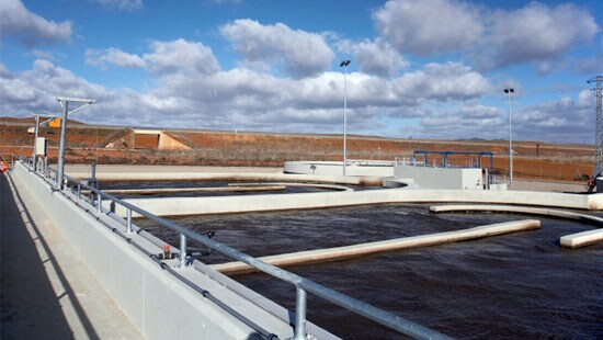 Worker treating wastewater at manufacturing facility