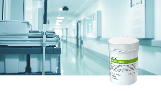 White container labeled 'Incidin Active' in the foreground, with a hospital corridor and cleaning cart in the background.
